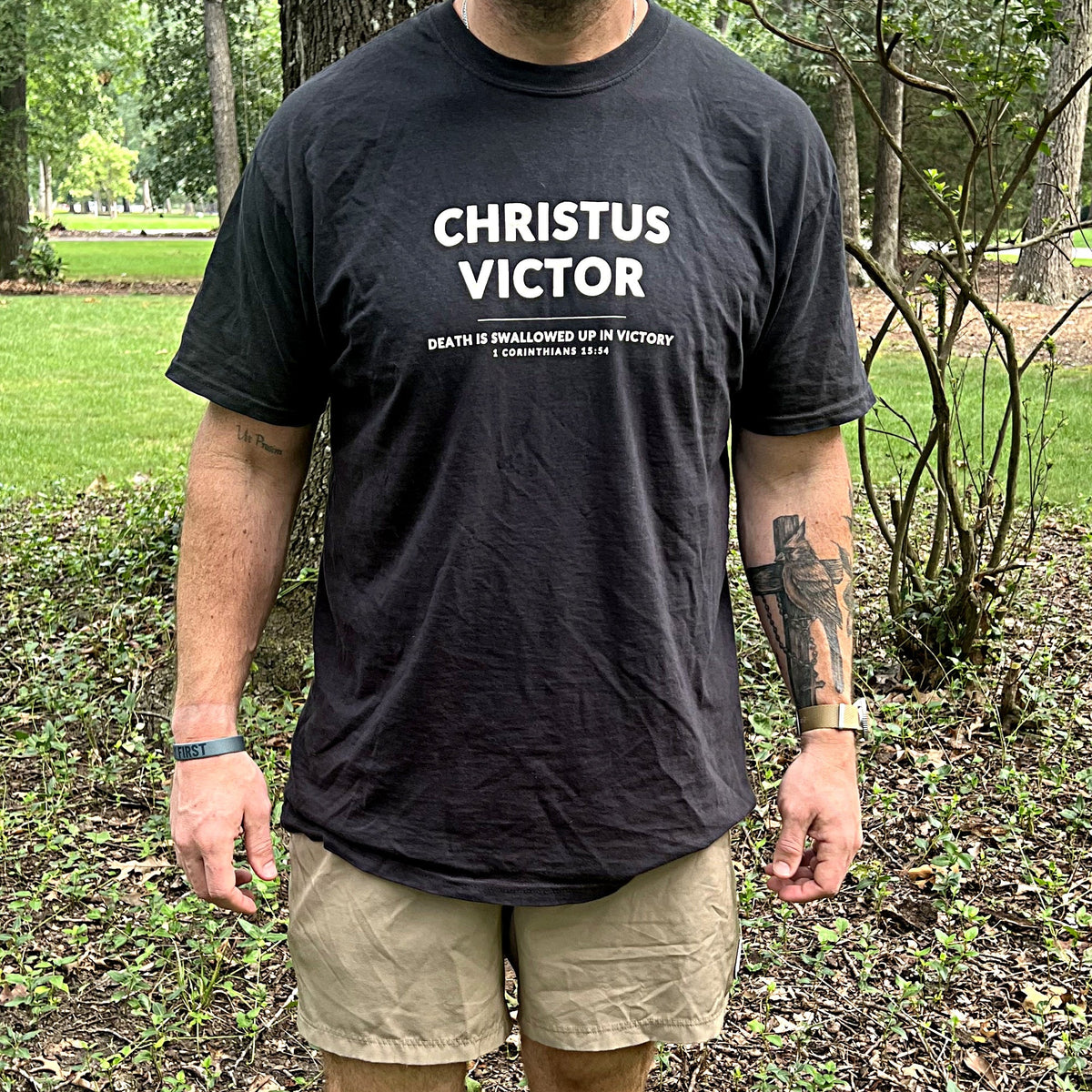 Man wearing the black Christus Victor tee outdoors