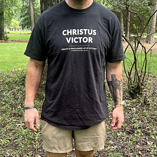 Man wearing the black Christus Victor tee outdoors