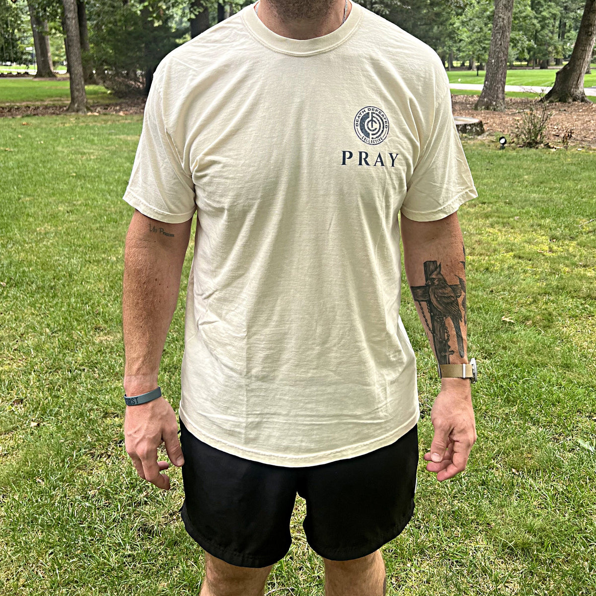 Man wearing the Pray tee, DDC seal and PRAY on the chest